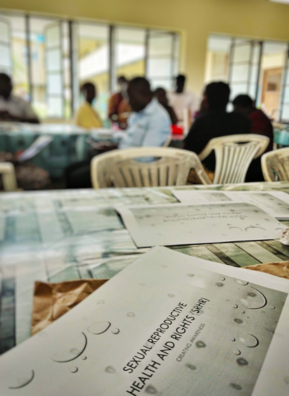 Photo of a workshop on sexual and reproductive health and rights with people sitting in the background of the photo. Photo.