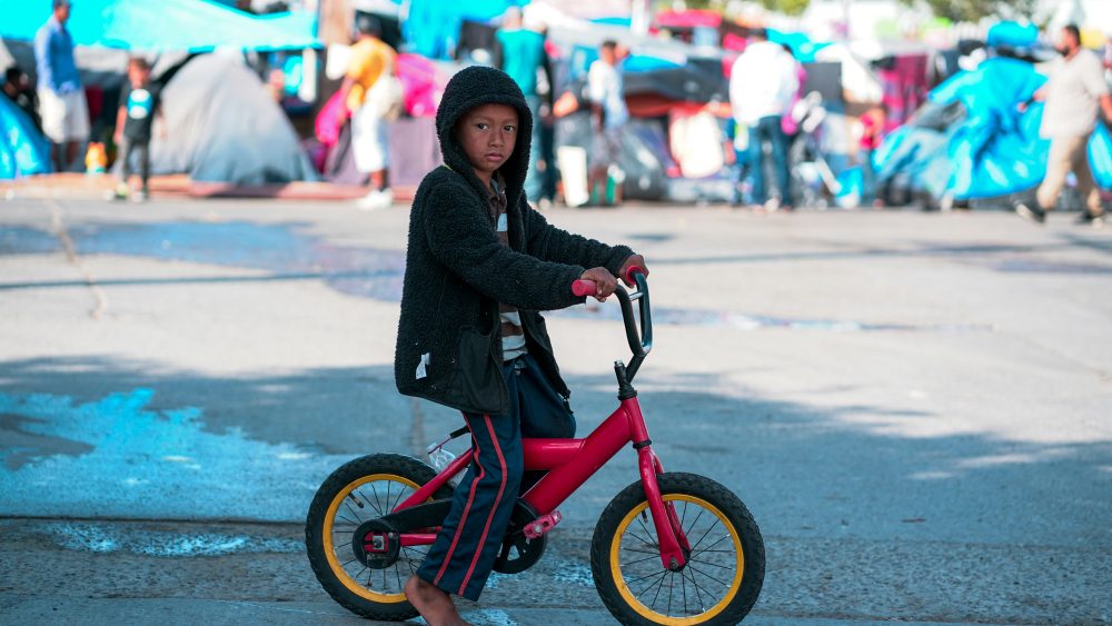 Picture of a child in front of a tent camp.
